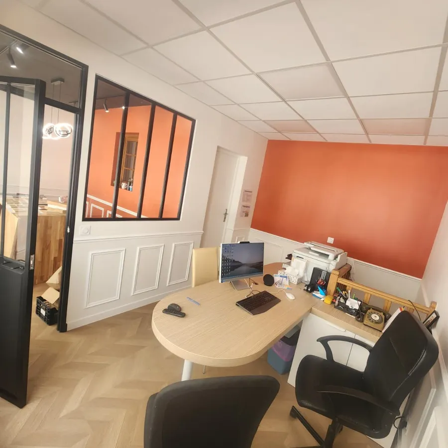 Poste de travail du bureau Sergio Renov : bureau en bois, fauteuils et verrière acier