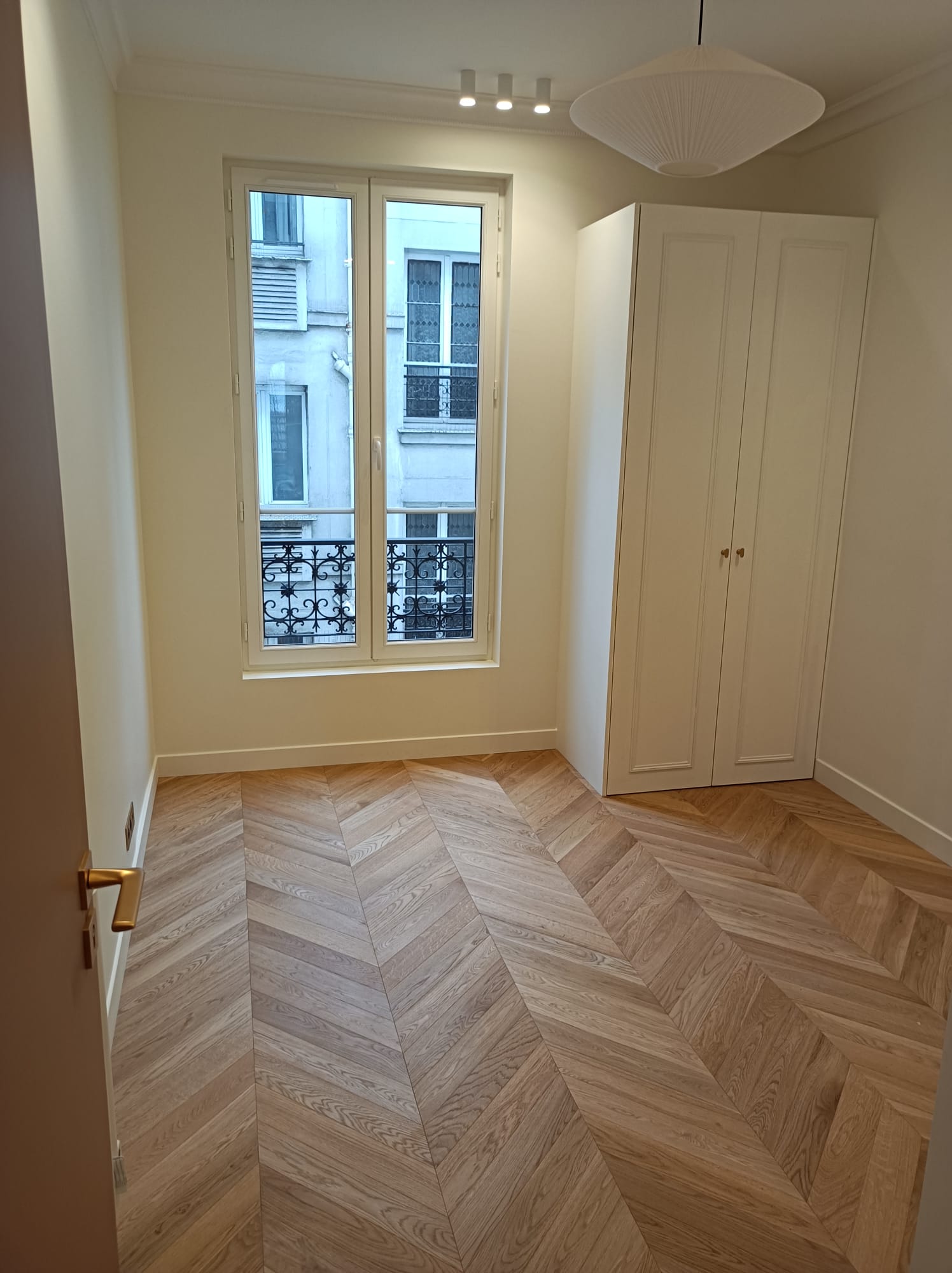 Chambre parquet chevron clair, fenêtre parisienne