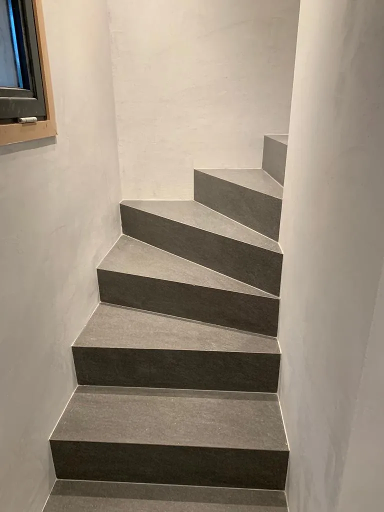 Escalier carrelé en grès cérame anthracite et béton ciré